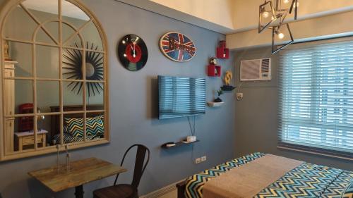 a dining room with a table and a mirror at Studio Premier Suite Makatii by Christine Suites PH in Manila