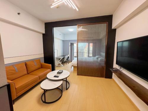 a living room with a couch and a television at Linjiang Shangpin Apartment in Guangzhou