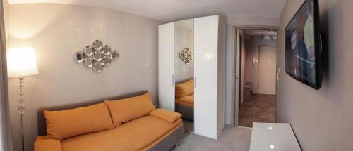a living room with a couch and a mirror at Villapark Luxury Apartman Balatonfüred in Balatonfüred