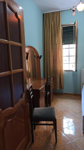 a dining room with a wooden table and a chair at Trumpets Apartment in Tirana