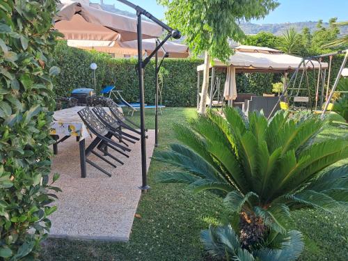 a garden with a bench and an umbrella and a swing at B&B Villa Rosa in SantʼAntonio Abate