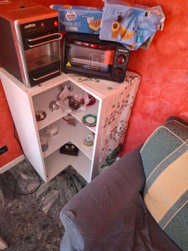 a small cabinet with a microwave and toys in it at Alle porte del Monterosa in Serravalle Sesia