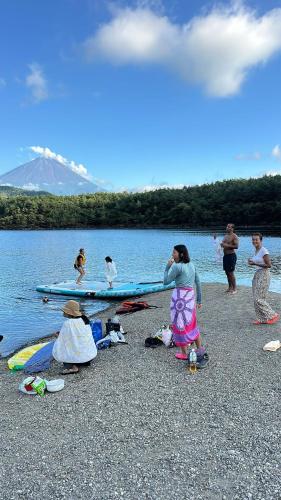 a group of people on the shore of a body of water at Fuji Dome Glamping in Fujikawaguchiko