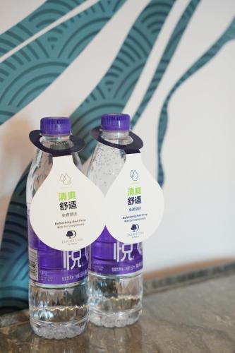 two bottles of water sitting on top of a table at Doubletree By Hilton Chengdu Xinglong Lake in Chengdu