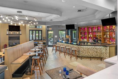 a restaurant with a bar with tables and chairs at Hilton San Diego/Del Mar in San Diego
