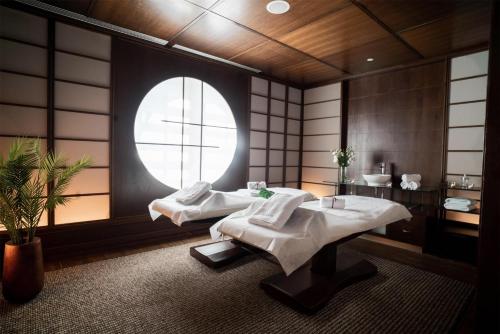 a spa room with two massage tables and a window at Hilton Warsaw City Hotel in Warsaw