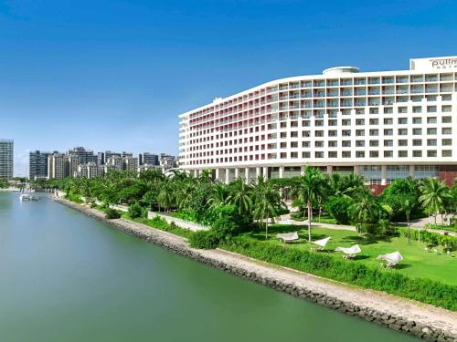 a large building next to a body of water at Pullman Haikou in Haikou