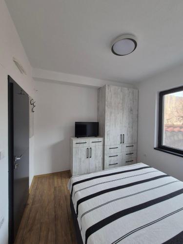 a white bedroom with a bed and a window at Villa Obednikovski in Ljubojno