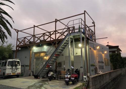 a building with a staircase on the side of it at Hostel und Kitchen GOTOBASE in Enokizu