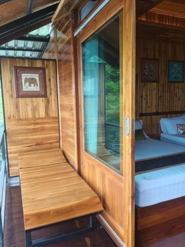 a wooden cabin with a small bed and a window at The Floating Lake House in Ban Pracham Mai Bon