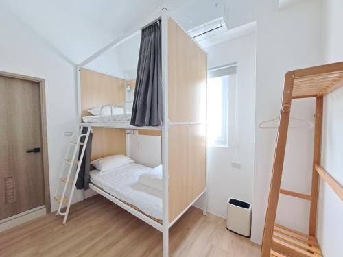 a room with two bunk beds and a ladder at 與浪共舞 in Xiyu