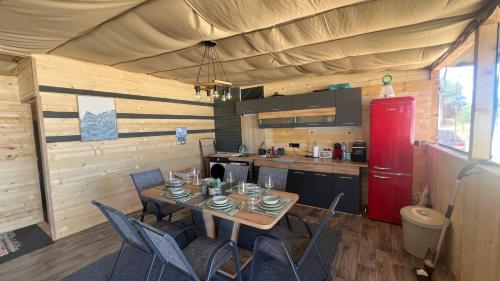 a kitchen with a table and chairs and a red refrigerator at Бунгало woodwave in Chernomorets