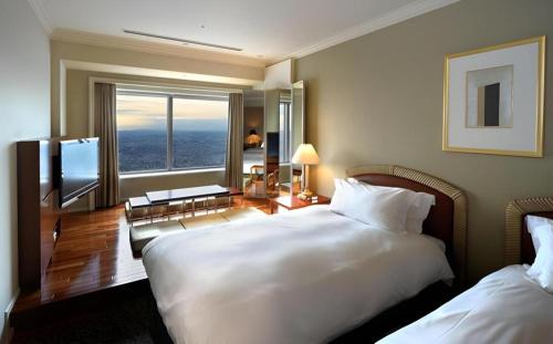 a hotel room with two beds and a large window at Yokohama Royal Park Hotel in Yokohama