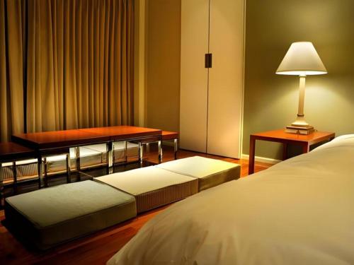 a bedroom with a bed and a table and a lamp at Yokohama Royal Park Hotel in Yokohama