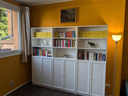 a room with white book shelves with books at An exclusive NEW apartment designed for modern living with timeless style in Bellano