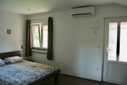 a bedroom with a bed and a window at House Magdic Plitvice in Grabovac