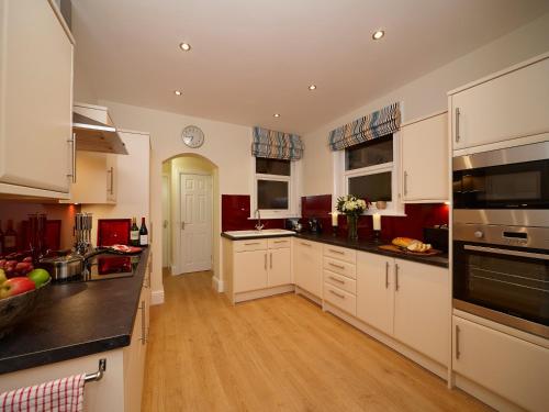 a kitchen with white cabinets and black counter tops at The Old Stables in Filey