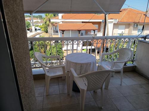 a table and chairs on a balcony with an umbrella at Chéz Vasŏ ** leisure maisonette** in Kassandria