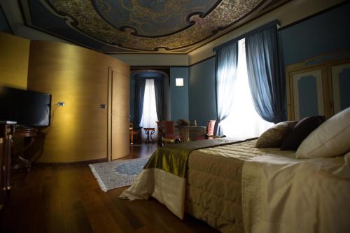 a bedroom with a large bed with a ceiling at Hotel Dei Pittori in Turin