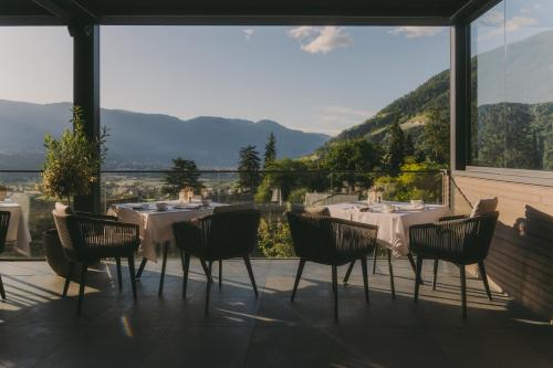 a dining room with tables and chairs on a balcony at Avidea - Adults Only in Lagundo