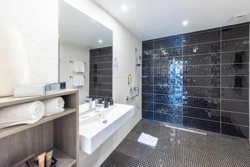 コリウールにあるLe Madeloc Hôtel & Spaの浴槽、洗面台、シャワーを備えたバスルーム