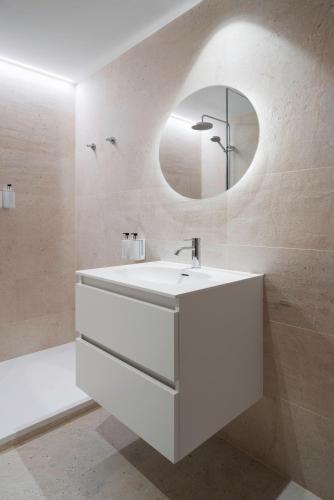 a white bathroom with a sink and a mirror at Ca Gracia Bocairent in Bocairent