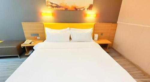 a bedroom with a large bed and a telephone at 7 Days Premium Xi'an Dayan Tower Xiaozhai Metro Station in Xi'an