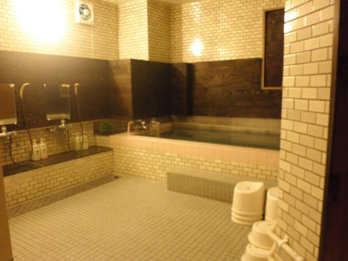 a bathroom with a tub and a toilet at Hotel Kamoike Plaza in Kagoshima