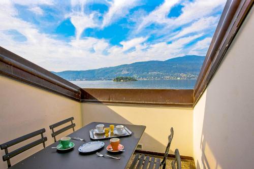 een tafel op een balkon met uitzicht op het water bij Appartamenti Lungolago in Verbania