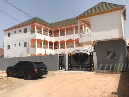 a black car parked in front of a house at MD guest house in Serekunda