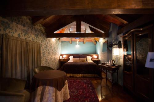 a bedroom with a bed and a chair and a table at Hotel Dei Pittori in Turin