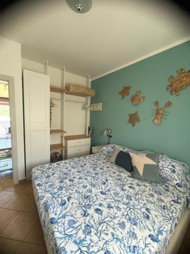 ein Schlafzimmer mit einem Bett mit einer blau-weißen Bettdecke in der Unterkunft Villetta Danila Pugnochiuso Le Macine in Vieste