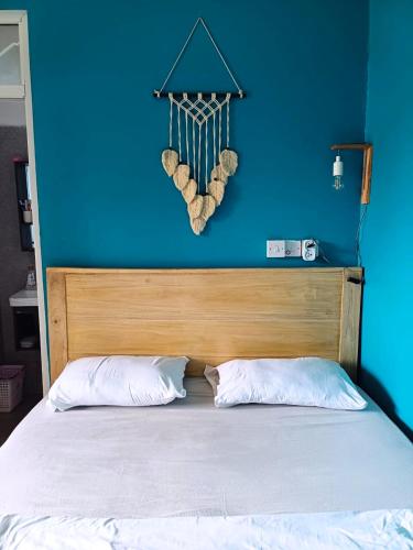a bedroom with a blue wall and a bed with two pillows at Bianca's Cottage - Whole House in Mikumi
