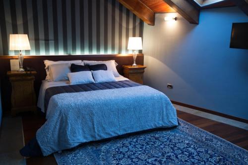 a bedroom with a large bed and two lamps at Hotel Dei Pittori in Turin
