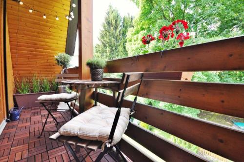 a porch with two chairs and a table and flowers at Pension Trautheim - Am Stadtpark in Bad Harzburg