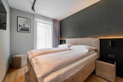 a bedroom with a large bed with a black wall at Apartament Marta Jastarnia - kompleks Wydma&Las in Jastarnia