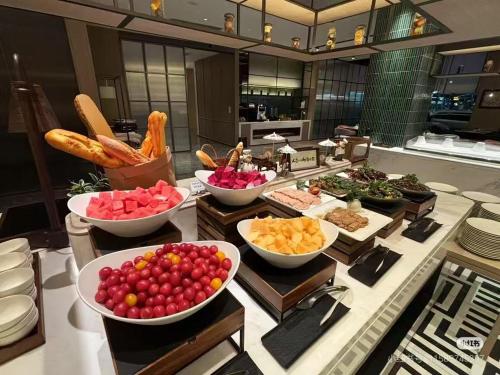a buffet with bowls of different types of food at Novotel Hangzhou Yuhang in Yuhang