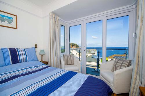 a bedroom with a bed and a view of the ocean at Seaview in Looe