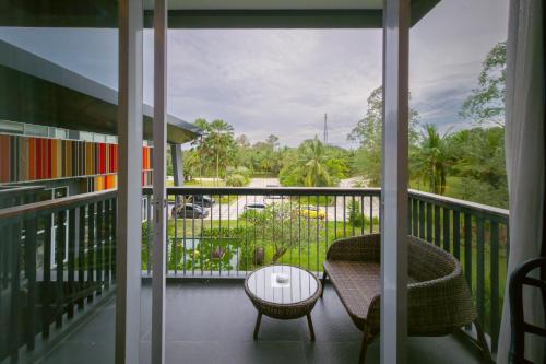 a room with a balcony with a table and a chair at Swiss-Belresort Belitung in Tanjungbinga