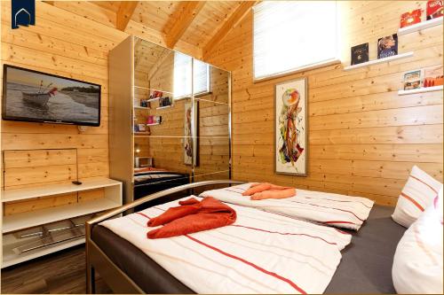 two beds in a room with wooden walls at Ferienhaus Villa Riesling in Zempin