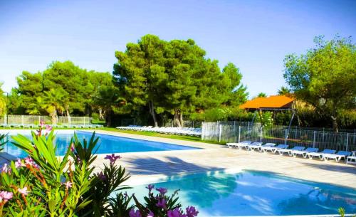 - une piscine entourée de chaises et d'arbres dans une cour dans l'établissement 2 Pièces 45m2, Calme, Confort, Mer à 200m, Jardin, Terrasse, Piscine, à Martigues