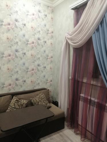 a living room with a couch and a wall with flowers at Cosy house in Aghk'ilisa
