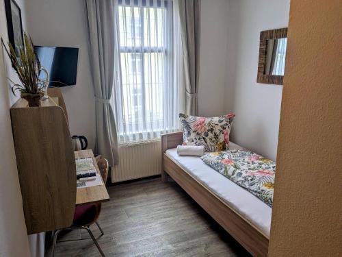 a small room with a bed and a window at Weisser Brunnen in Gotha