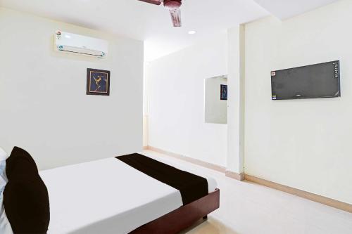 a room with a bed and a tv on a wall at Hotel O Guduvancheri Railway Station in Chennai