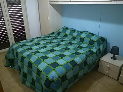 ジノーザ・マリーナにあるApartment Cのベッドルーム1室(青と緑の掛け布団付きのベッド1台付)