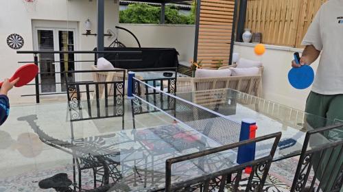 a man standing on a balcony with a glass table at Lovely House in Besançon