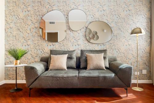 ein Wohnzimmer mit einem Sofa und 2 Spiegeln in der Unterkunft NEW-Venice Suite San Marco 397 in Venedig