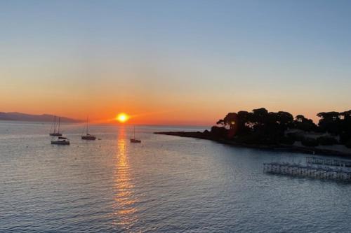 un coucher de soleil sur une étendue d'eau avec des bateaux dans l'établissement Beautiful 41 m with balcony, à Antibes