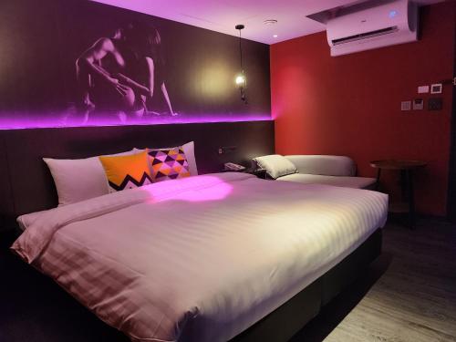 a bedroom with a large bed with purple lighting at Goldinn Hotel in Taipei