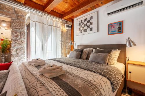 a bedroom with a large bed and a window at St Roko - Cozy Stone Studio in Old Town Korčula in Korčula
